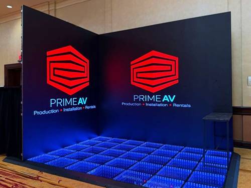 LED video walls and digital signage on a trade show floor by Prime AV