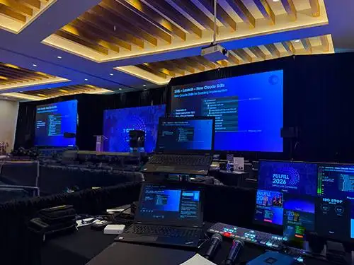 Conference general session with stage, lighting and large video screens produced by Prime AV